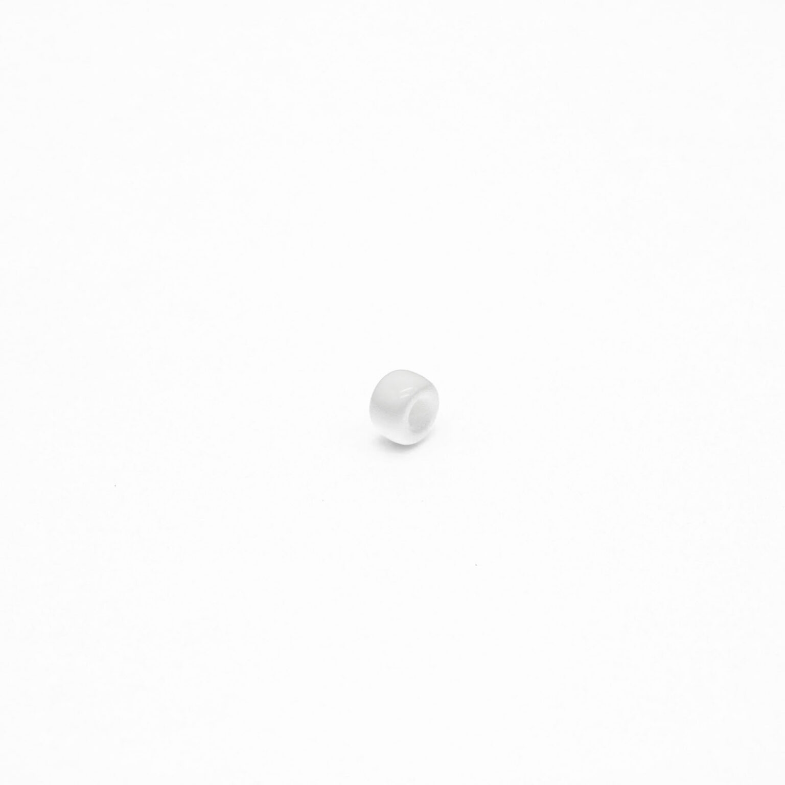 This is a bead, made from plastic and White in colour.
